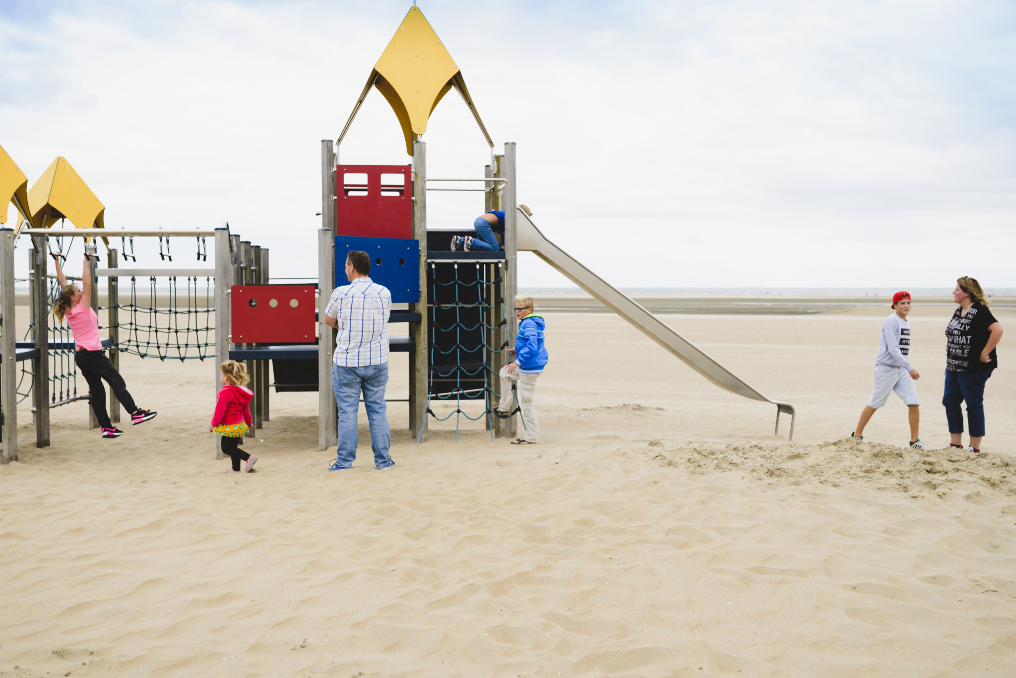 heel mijn gezin op een speeltoestel op het strand, documentaire fotografie