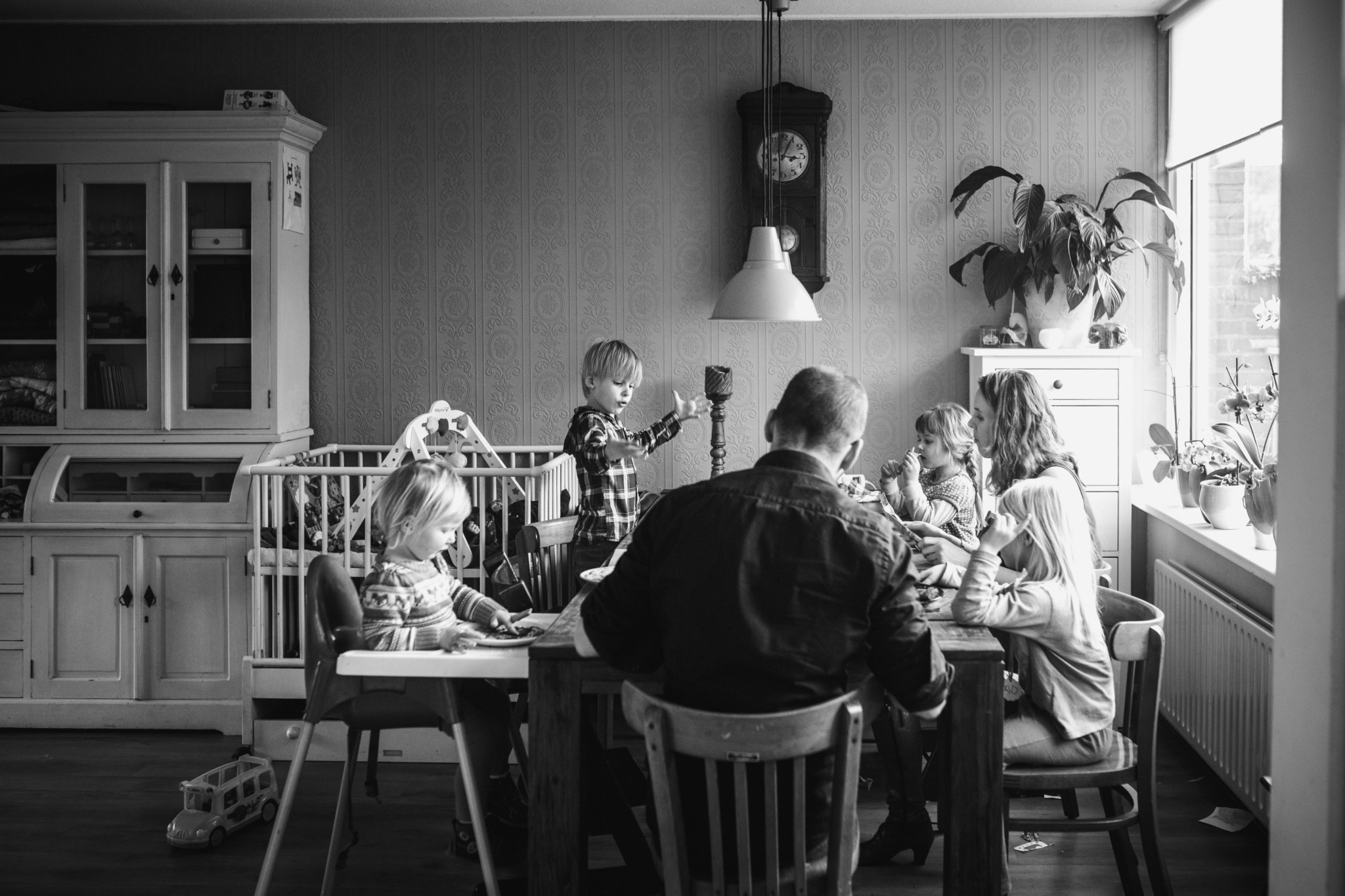 Groot gezin met vijf kinderen eet pannenkoeken, documentaire fotografie