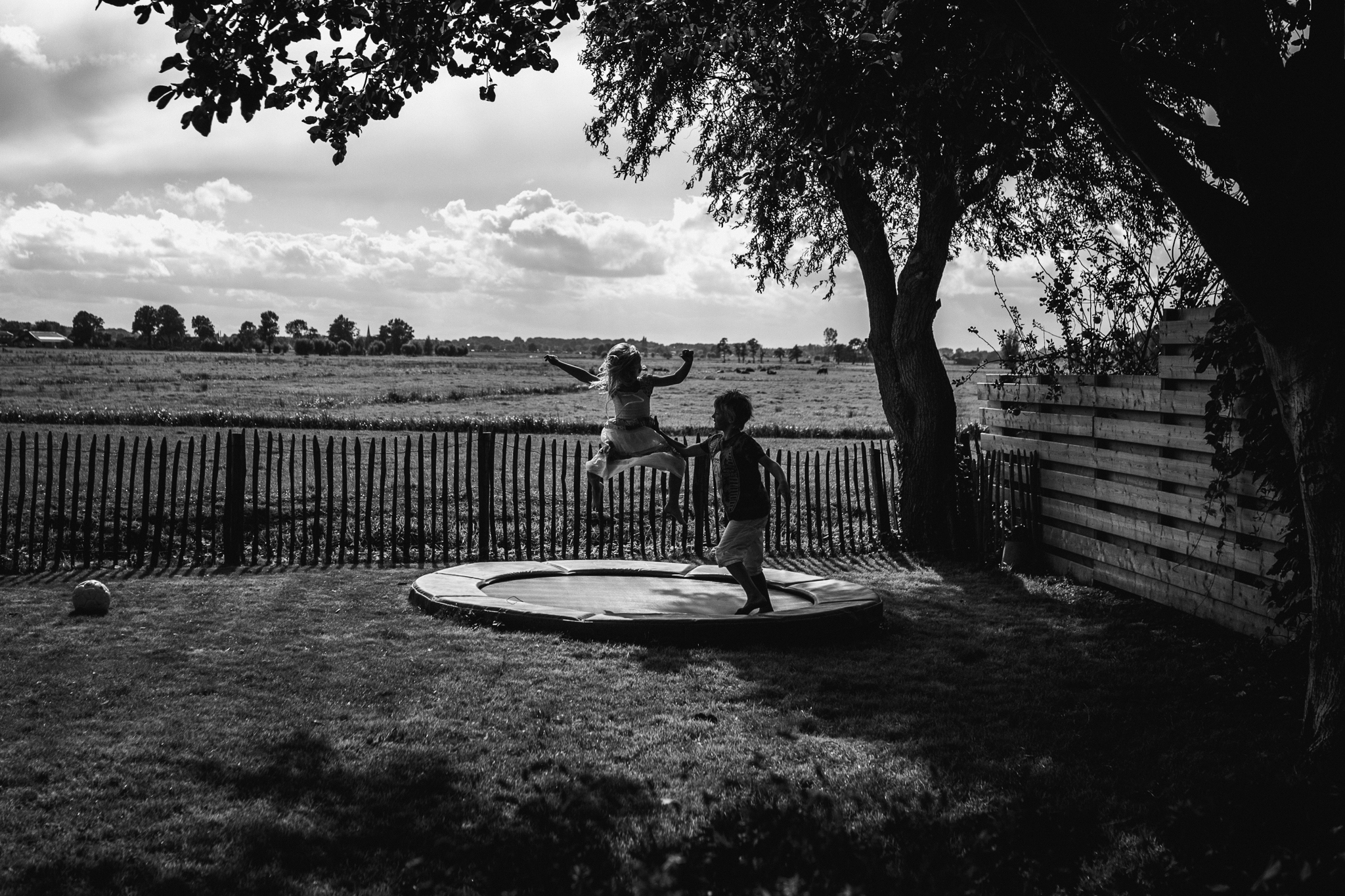 Silhouette van twee kinderen op trampoline, kinderfotografie