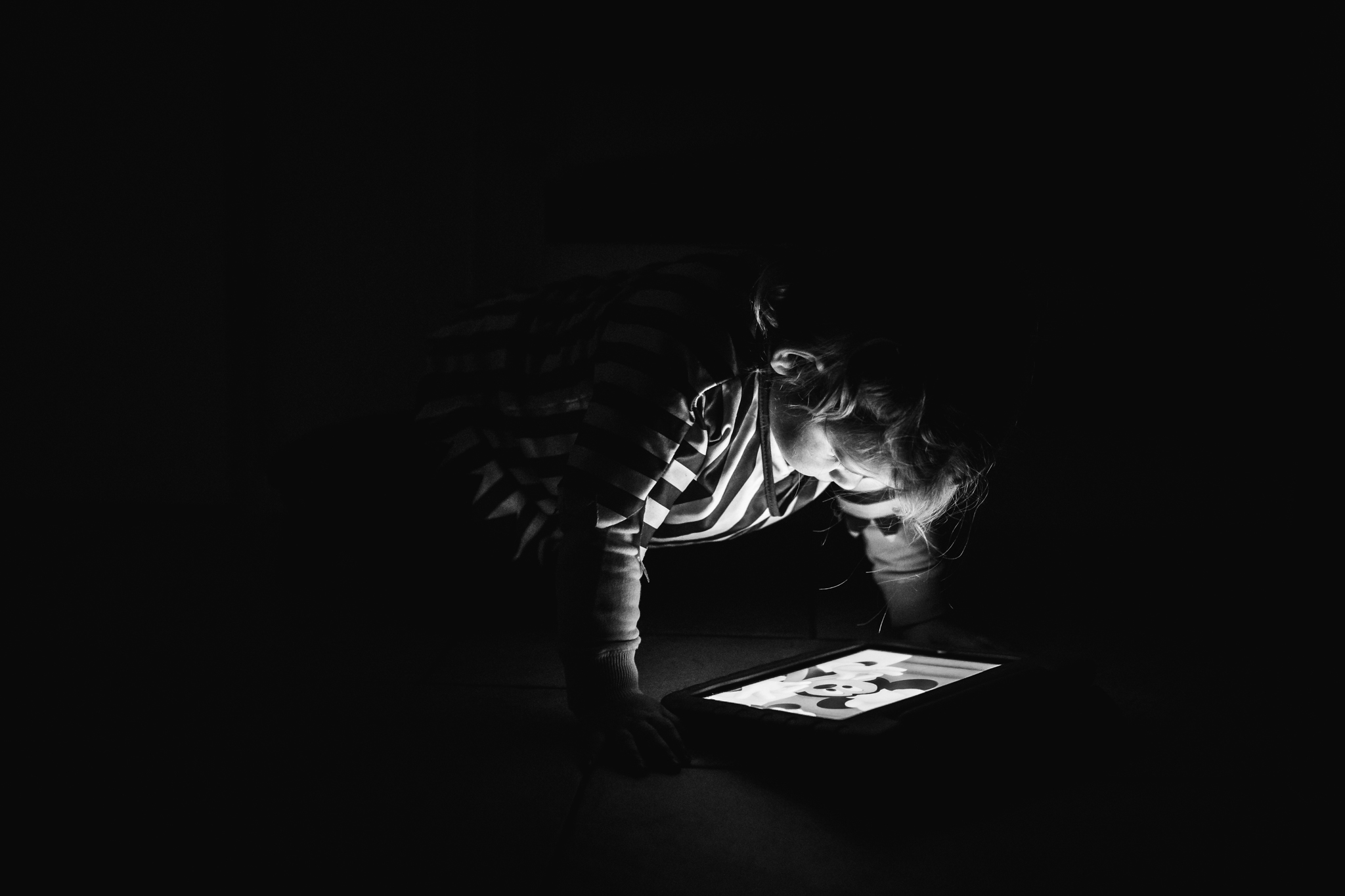 Meisje kijkt in het donker naar haar Ipad , lifestyle fotografie