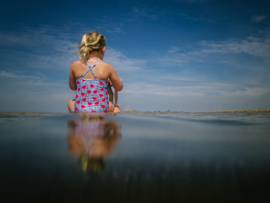 Meisje op het strand met mooie reflectie, vakantiefotografie
