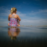 Meisje op het strand met mooie reflectie, vakantiefotografie
