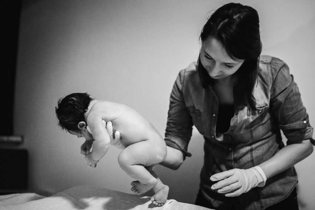Verloskundige test de loopreflex van een pasgeboren baby