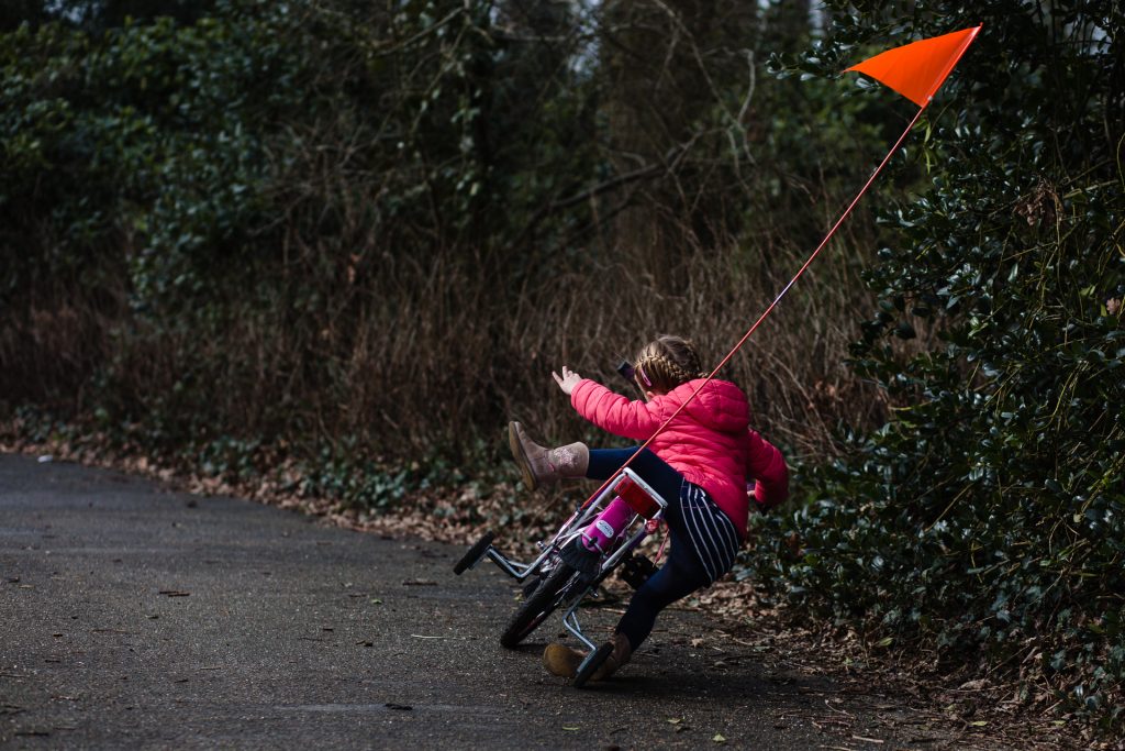 Peutertje valt van haar fiets met zijwielen tijdens een fotoreportage van het gezin