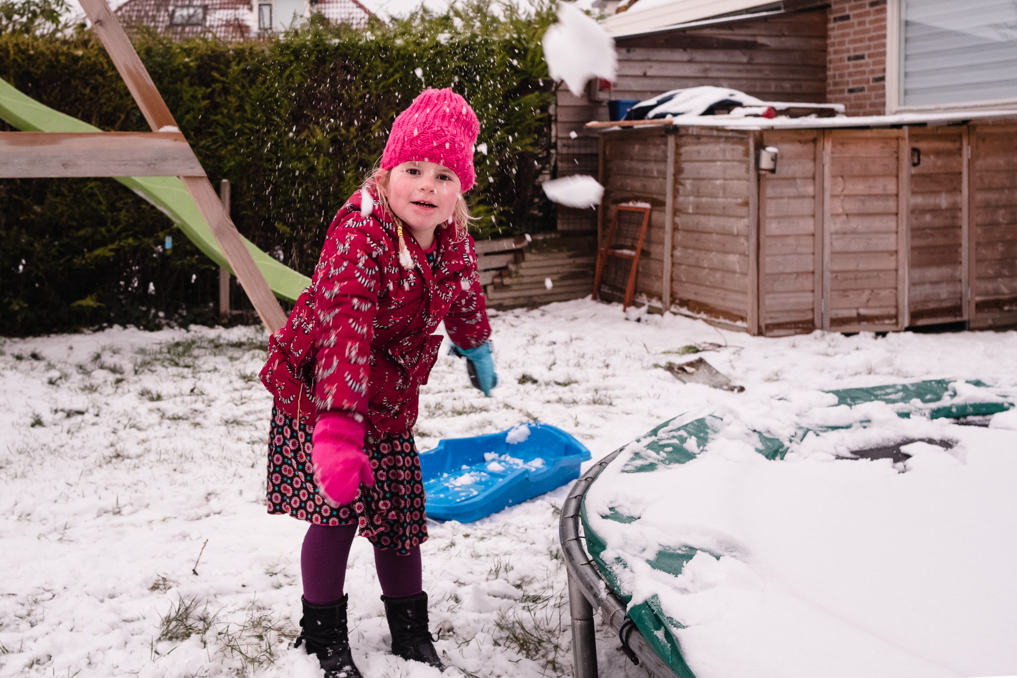 Meisje gooit met sneeuwbal in de sneeuw, eindelijk sneeuwpret in Nederland