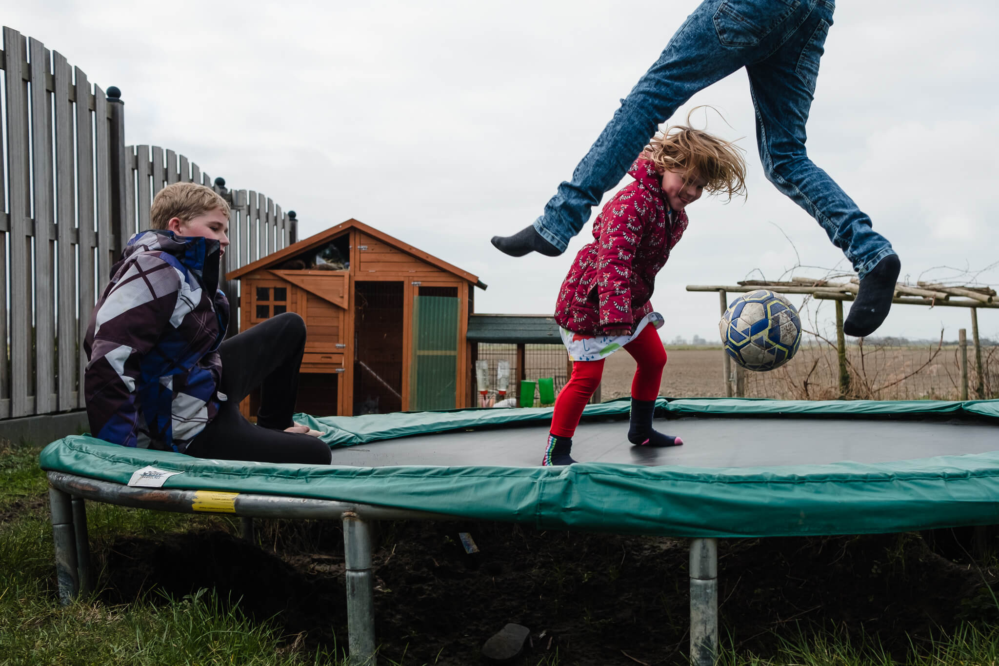 kinderen spelen buiten op de trampoline, documentaire familiefotografie