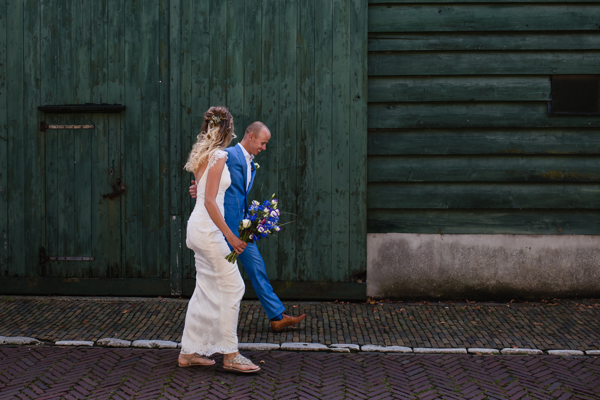Bruid en bruidegom voor groene deur in Goedereede op Goeree-Overflakkee