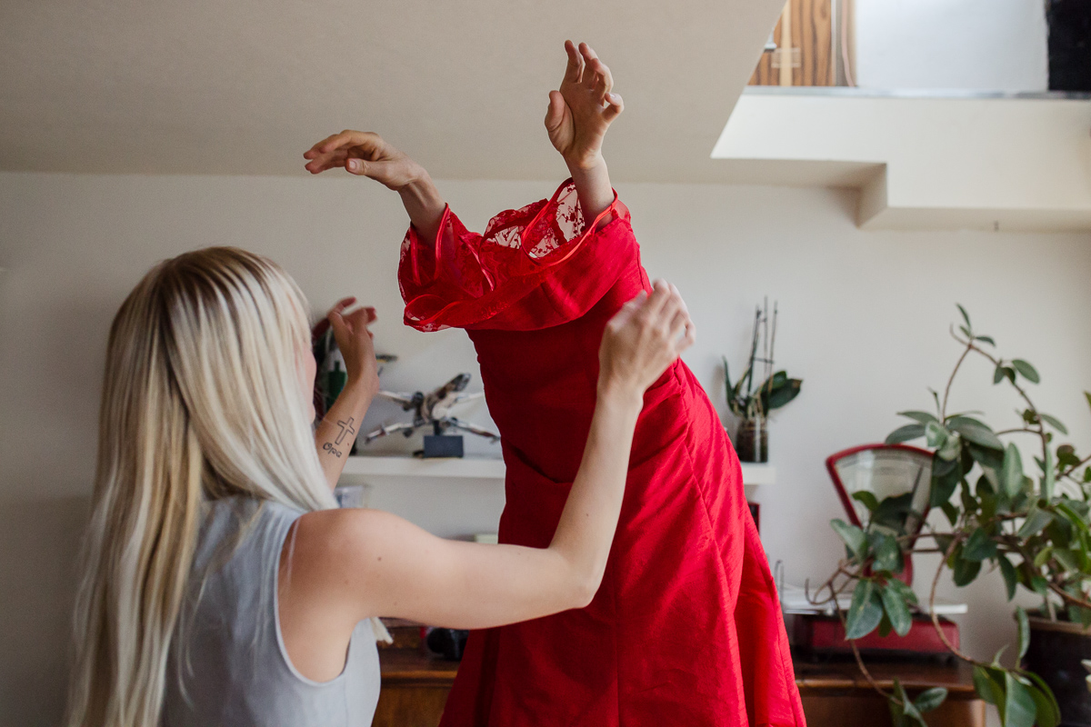 Bruid wordt geholpen bij het aantrekken van haar jurk - Bruidsfotograaf marjolijn maljaars