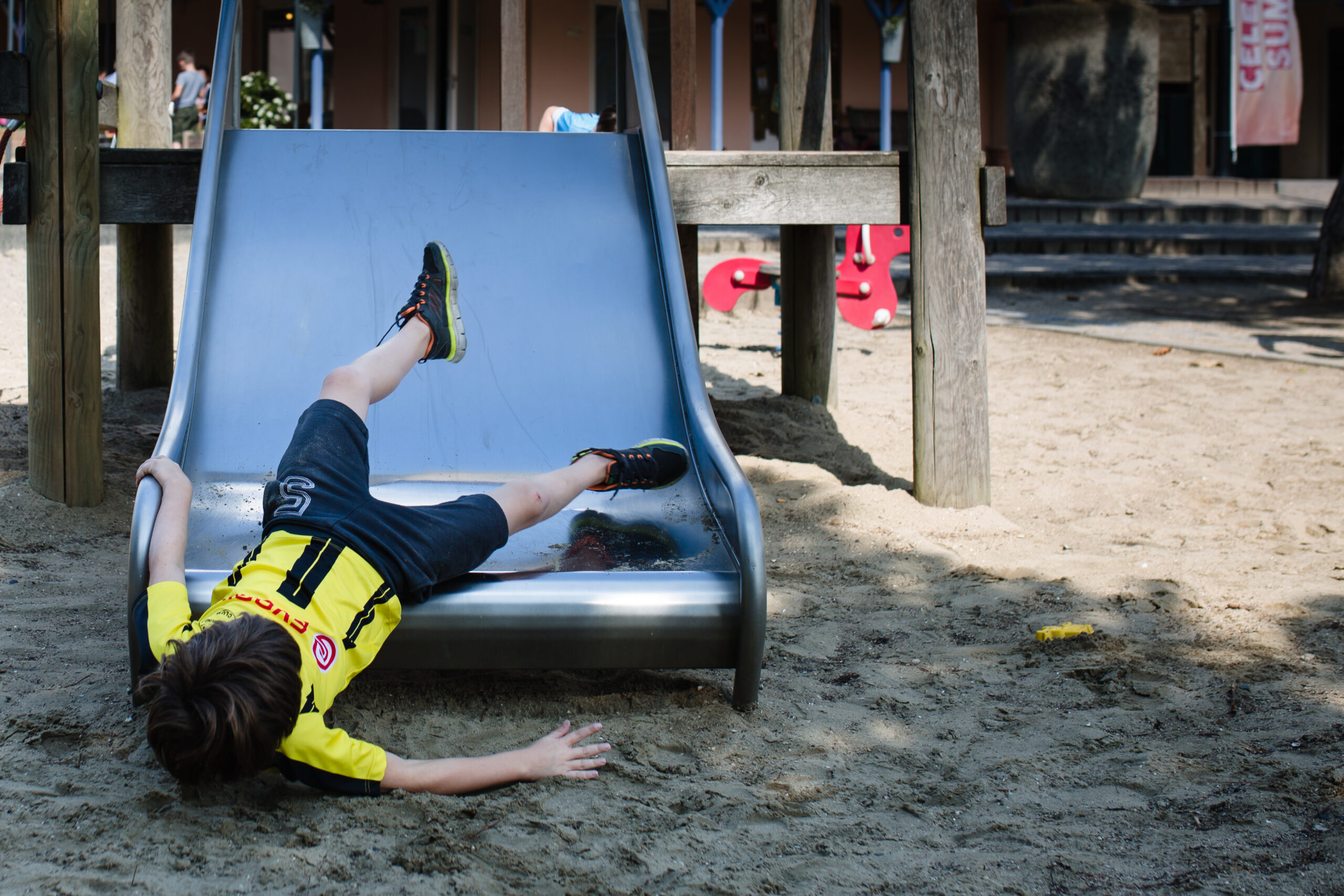Jongentje glijdt achterstevoren van glijbaan in de speeltuin bij Center Parcs Port Zelande. De vakantie wordt vastgelegd door een fotograaf, marjolijn maljaars van maljaars fotografie, door middel van een vakantiereportage